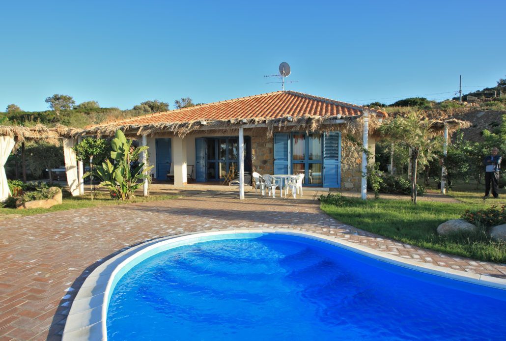 C'è una grande piscina davanti a una casa.