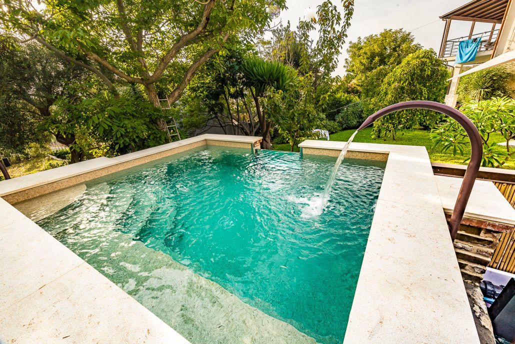 Una piccola piscina con una fontana al centro.
