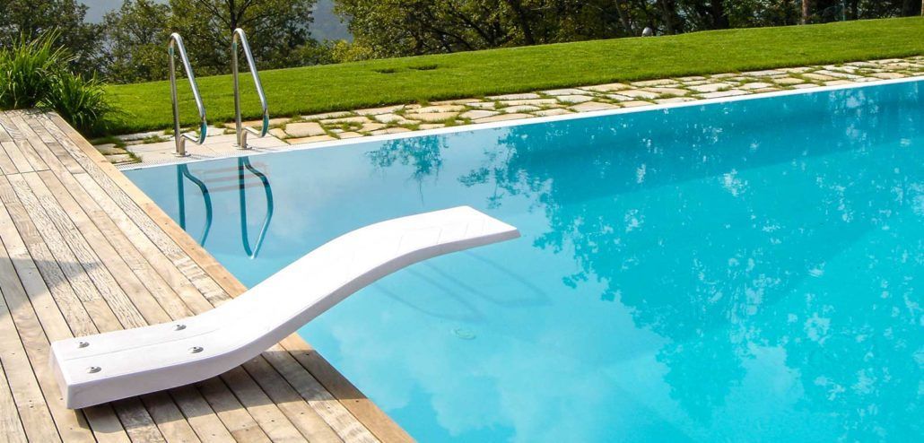 Un trampolino è posizionato sul bordo di una piscina.