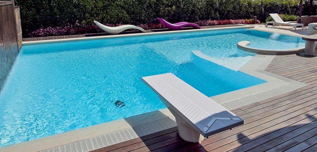 Una grande piscina con un trampolino al centro.