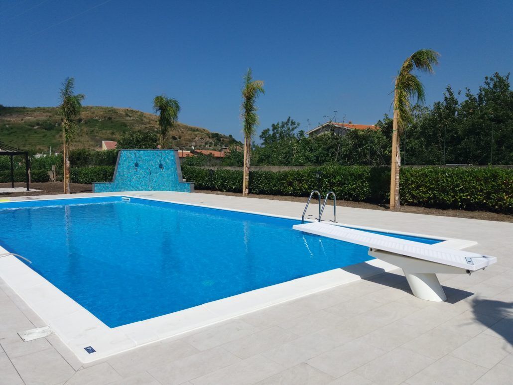 Una grande piscina con trampolino al centro