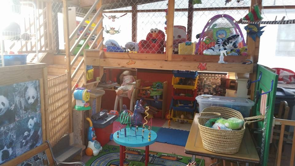 Playhouse filled with toys; dolls, baskets, a tent, and various colorful items.