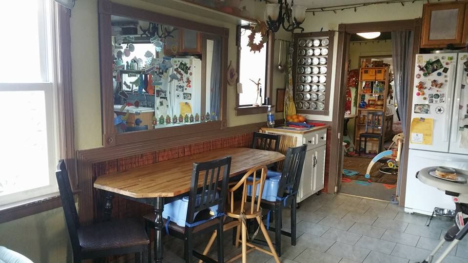 Kitchen with a dining table, chairs, and a large mirror. Brown trim and wood table.