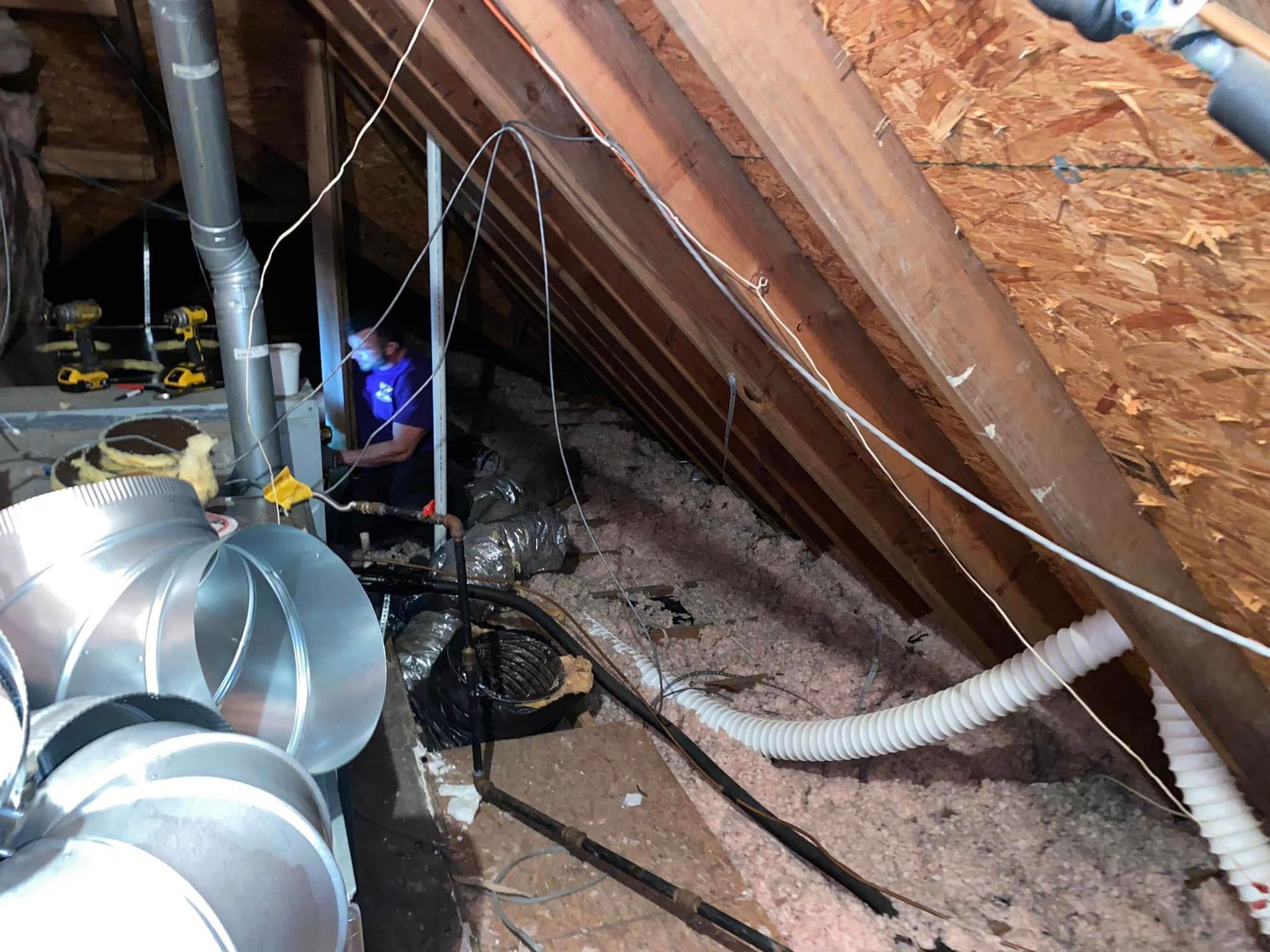 A man is working in the attic of a house.