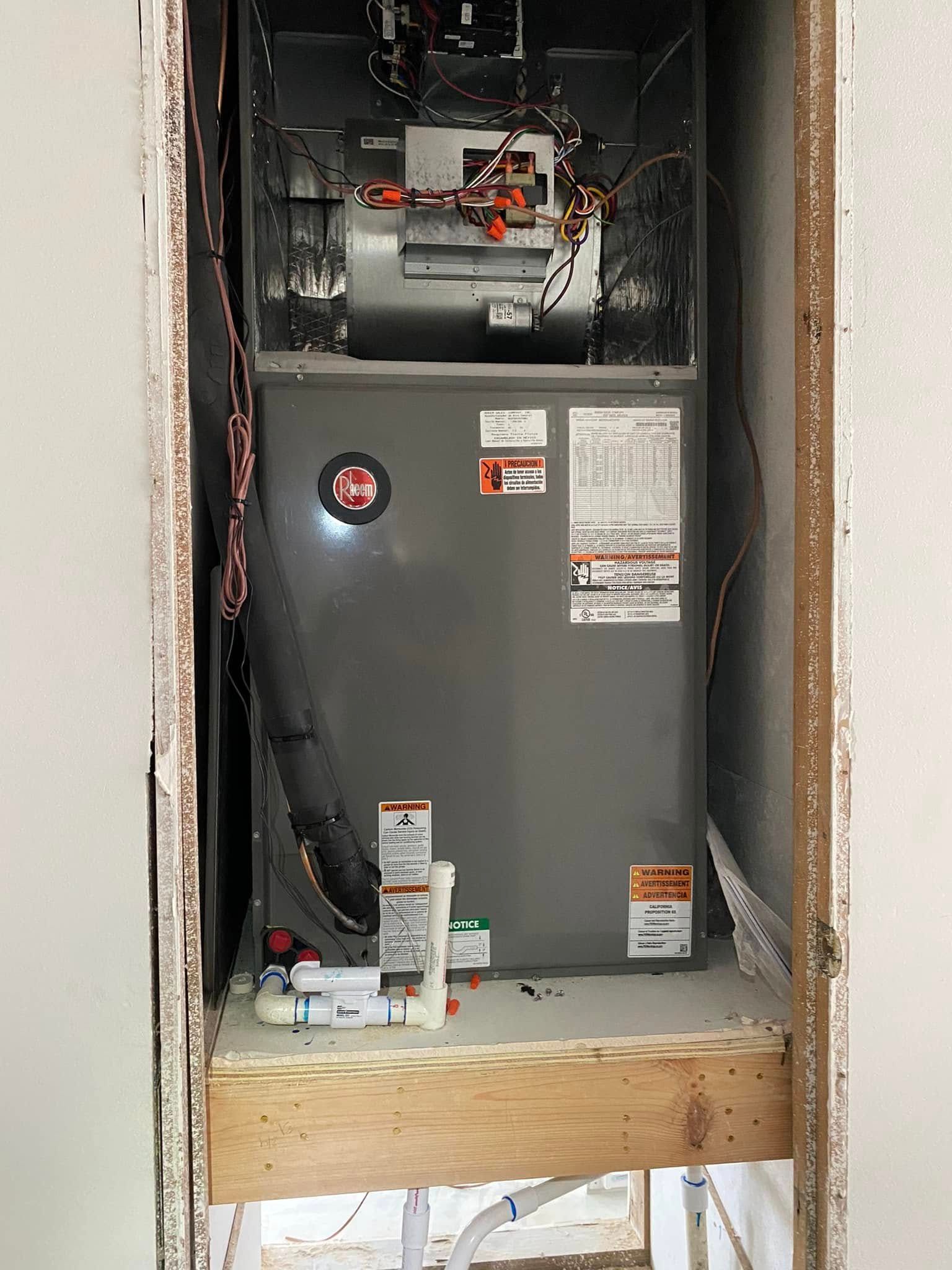 An air conditioner is sitting inside of a doorway in a room.