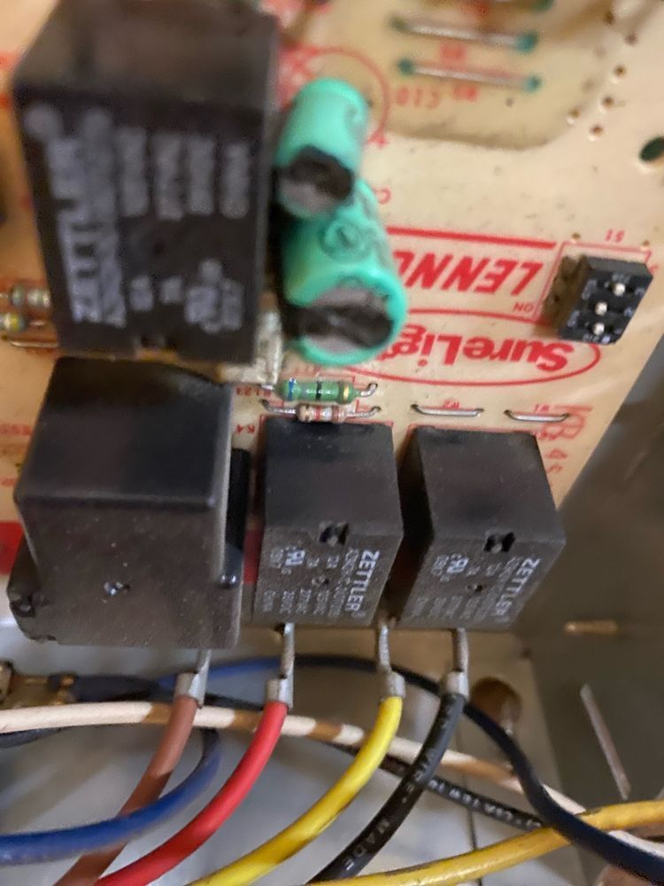 A bunch of wires are connected to a board that says lennox