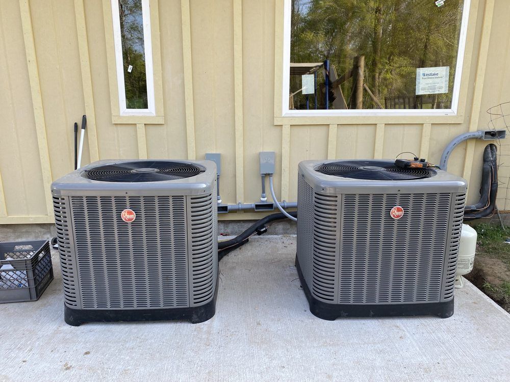 Two air conditioners are sitting on the side of a building.