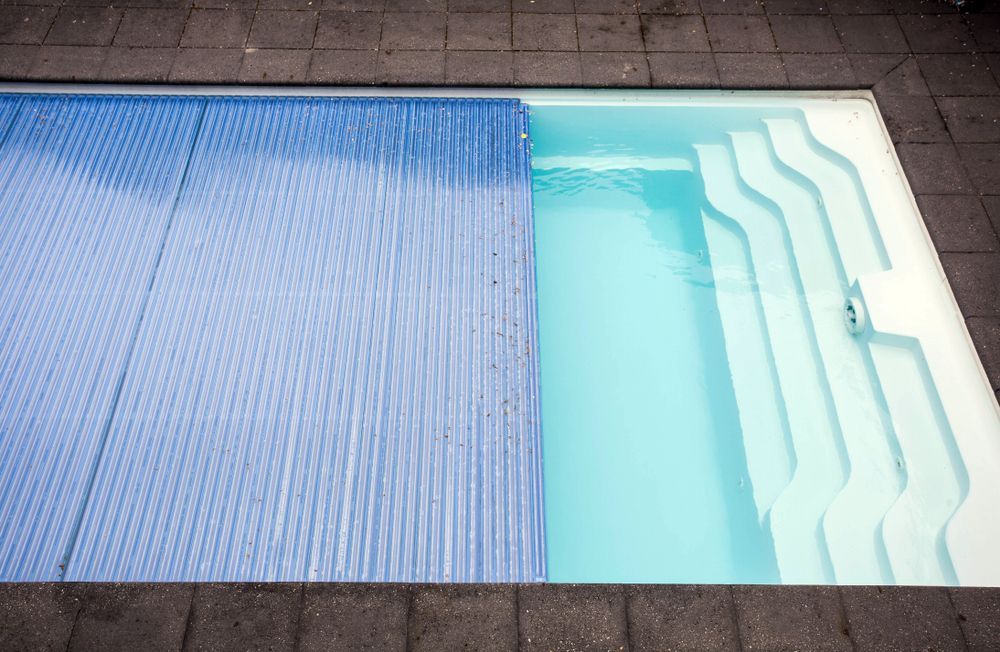 Swimming Pool With A Blue Cover — Beaches Pool Supplies in Kewarra Beach, QLD
