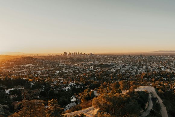 A view of a city from a hill at sunset.