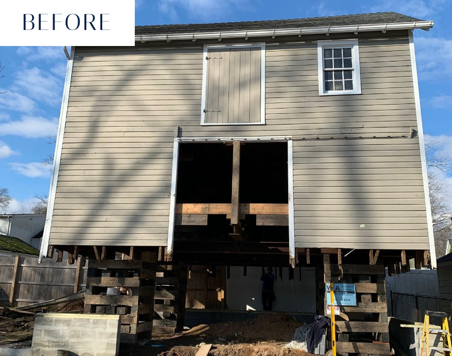 Before photo of a two-story building raised on wooden supports, likely undergoing construction or renovation.