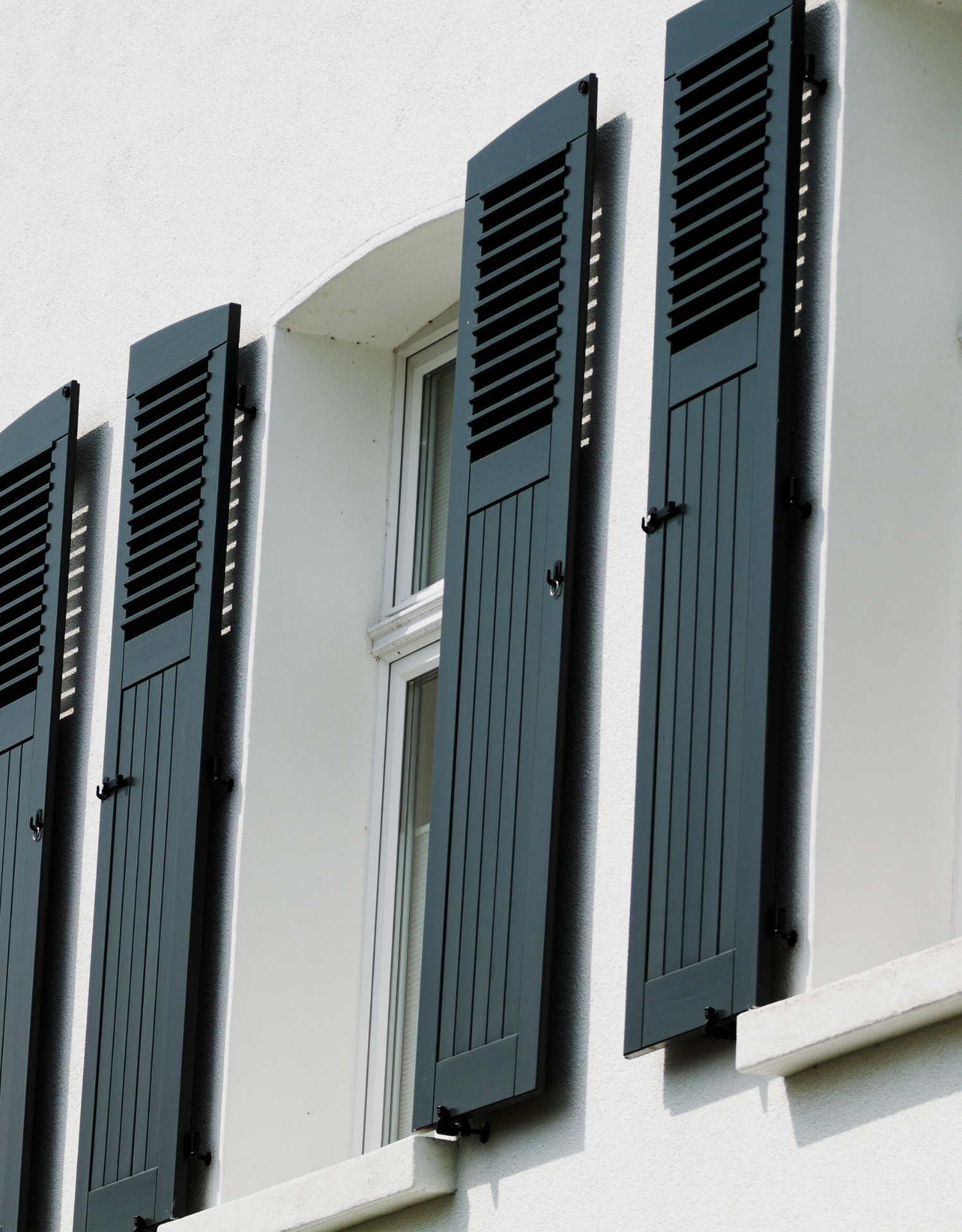 Pièce vide aux murs bleus, porte coulissante en verre donnant sur un balcon et lumière naturelle.