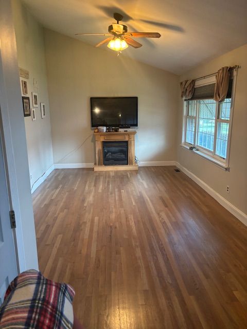 Living room renovation featuring new paint, ceiling fan installation and updated window accents.