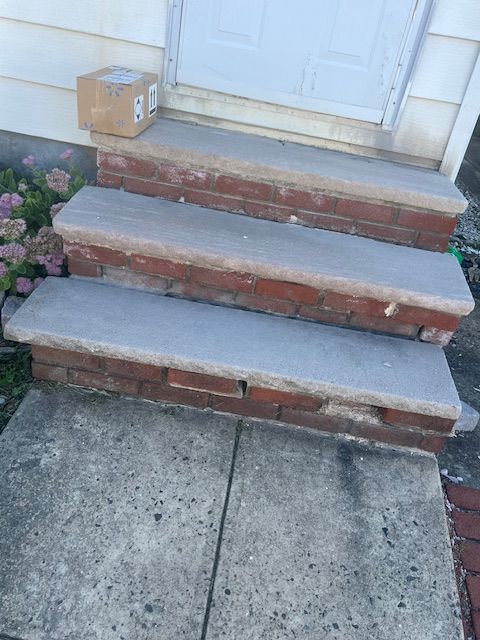 Front entry step repair showing brick replacement and restored porch access.