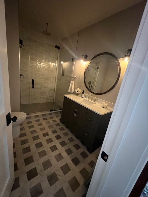 Modern bathroom remodel with glass shower, tile wall upgrades and updated lighting fixtures.