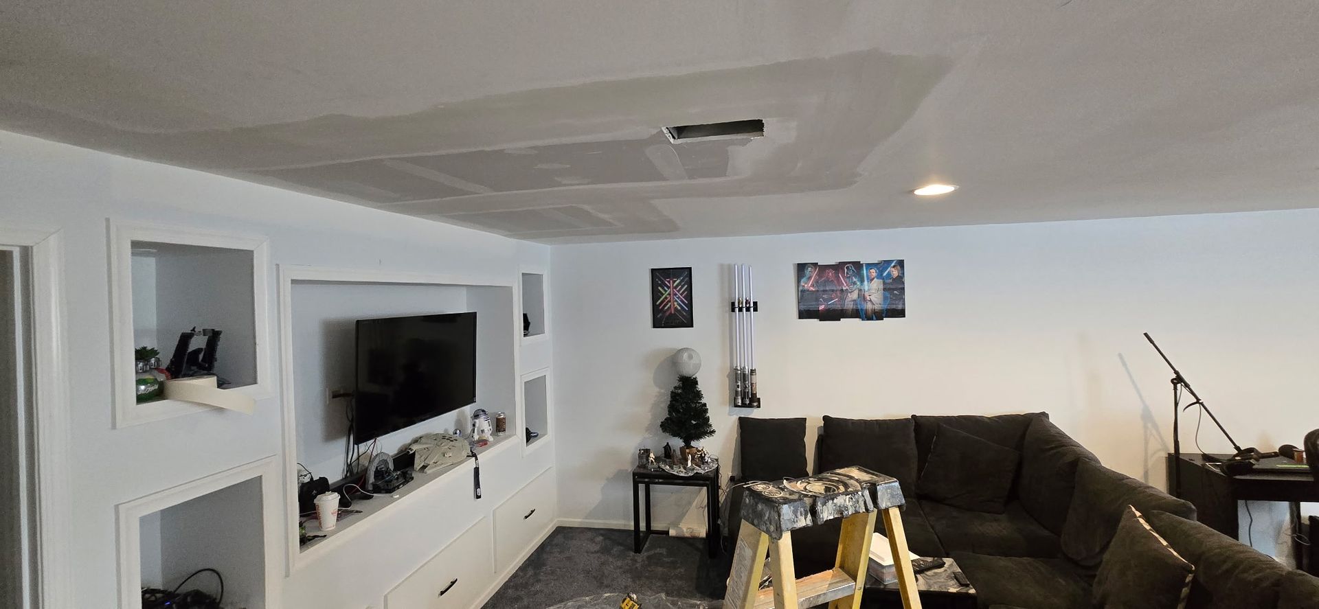 Basement remodel with drywall finishing, recessed lighting and built-in entertainment wall.
