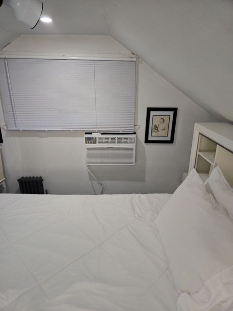 Interior ceiling and wall refinishing project with new trim and fresh paint in attic room.