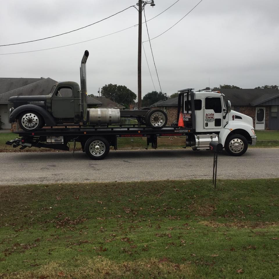 A tow truck with a car on the back of it