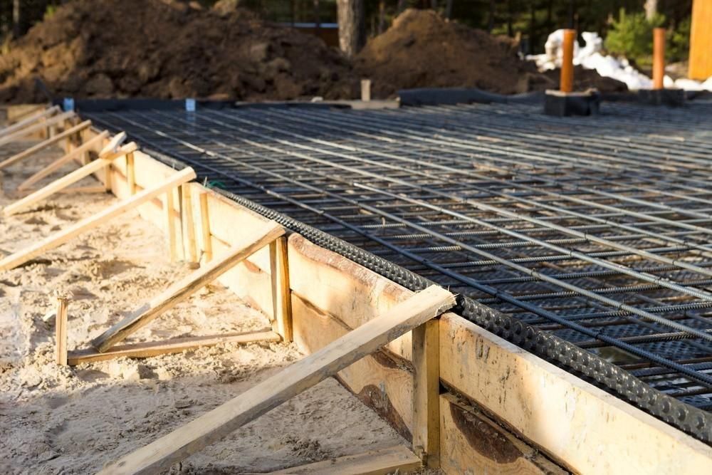 A concrete foundation is being built on a construction site.