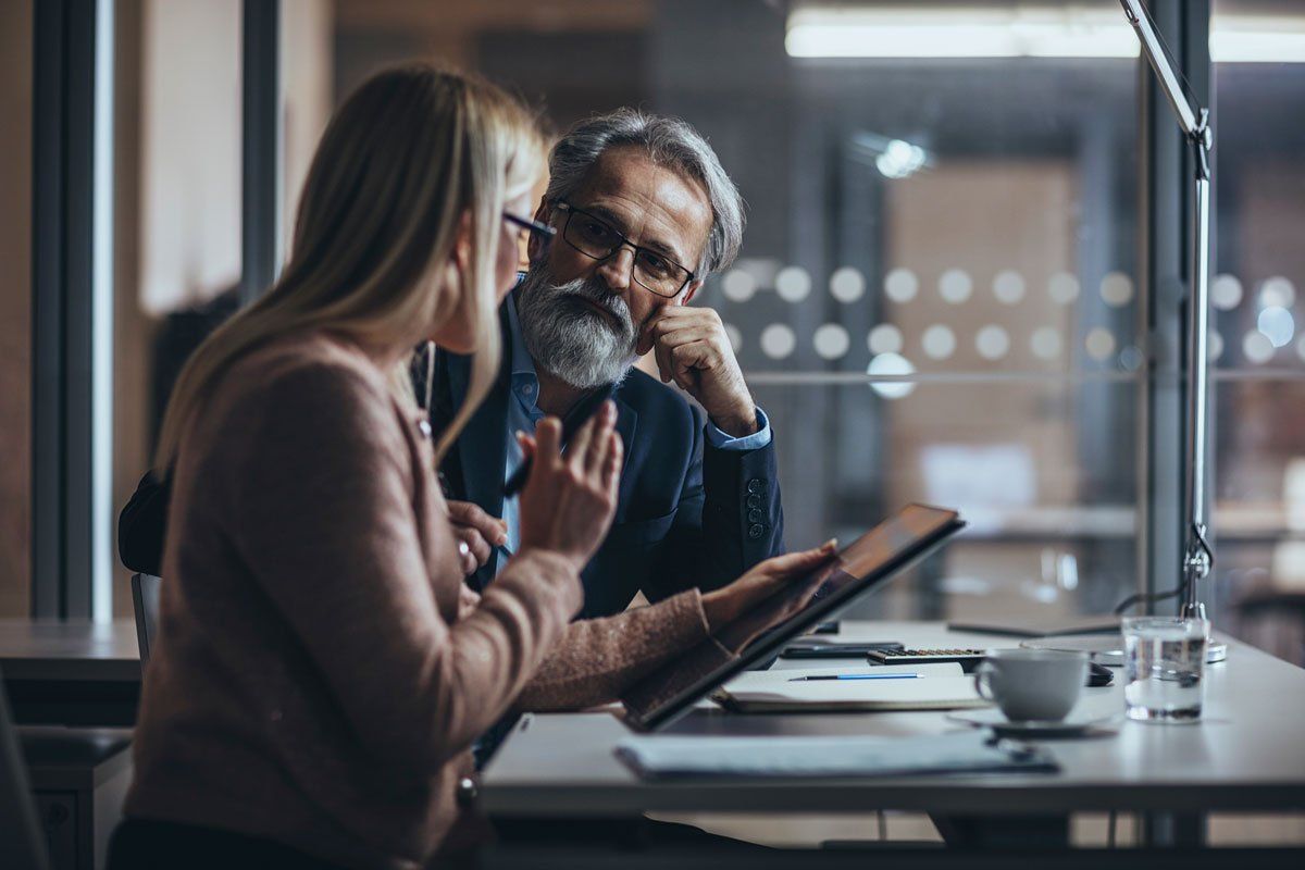 A man and woman discuss business in a coffee shop