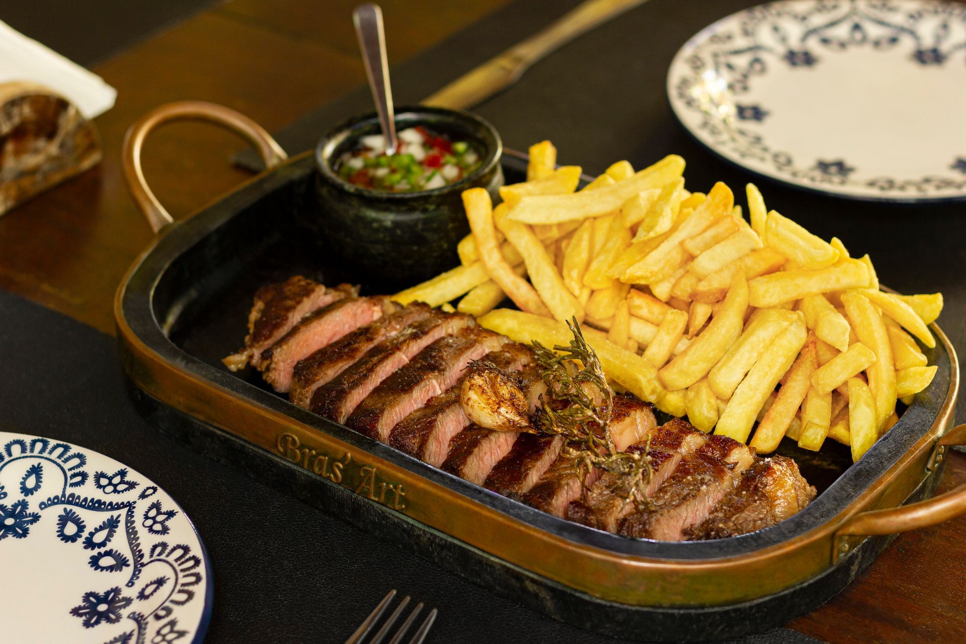 a plate of steak and french fries on a table .