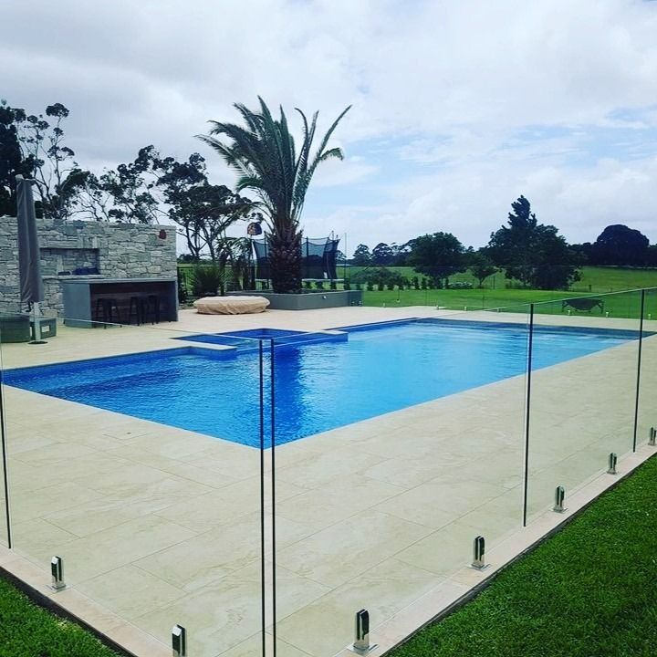 A Large Swimming Pool With A Glass Fence Around It — Ballina Pool Shop In Byron Bay, NSW
