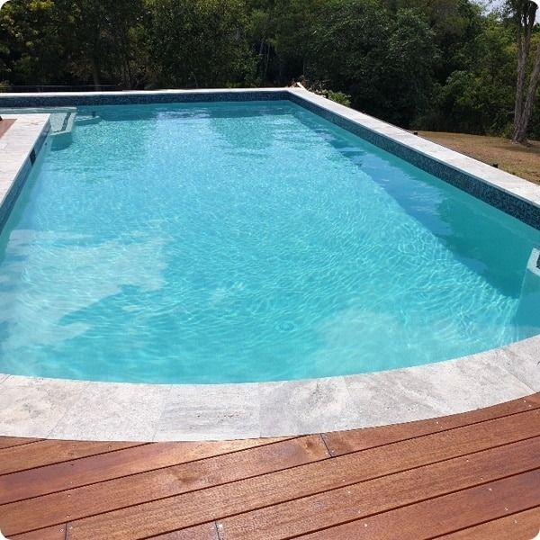 A Large Swimming Pool Is Surrounded By Trees And A Wooden Deck — Ballina Pool Shop In Ballina, NSW