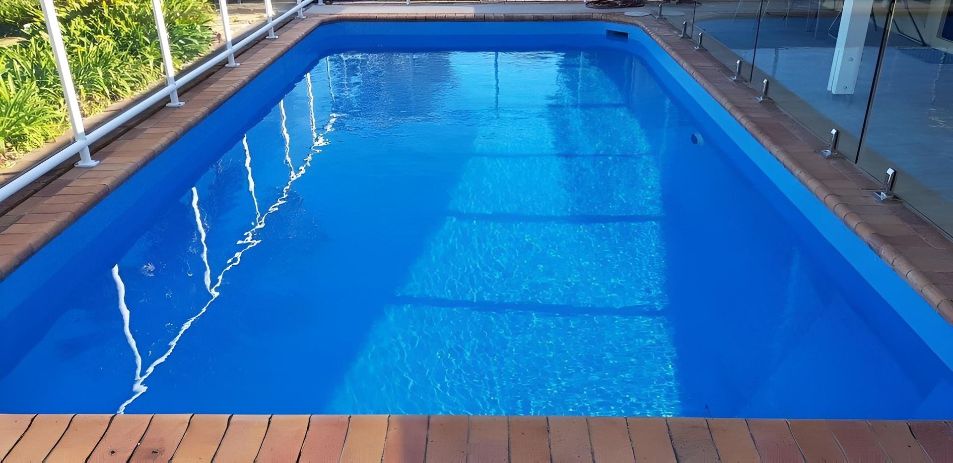 A Large Blue Swimming Pool Is Sitting On Top Of A Wooden Deck — Ballina Pool Shop In Ballina, NSW