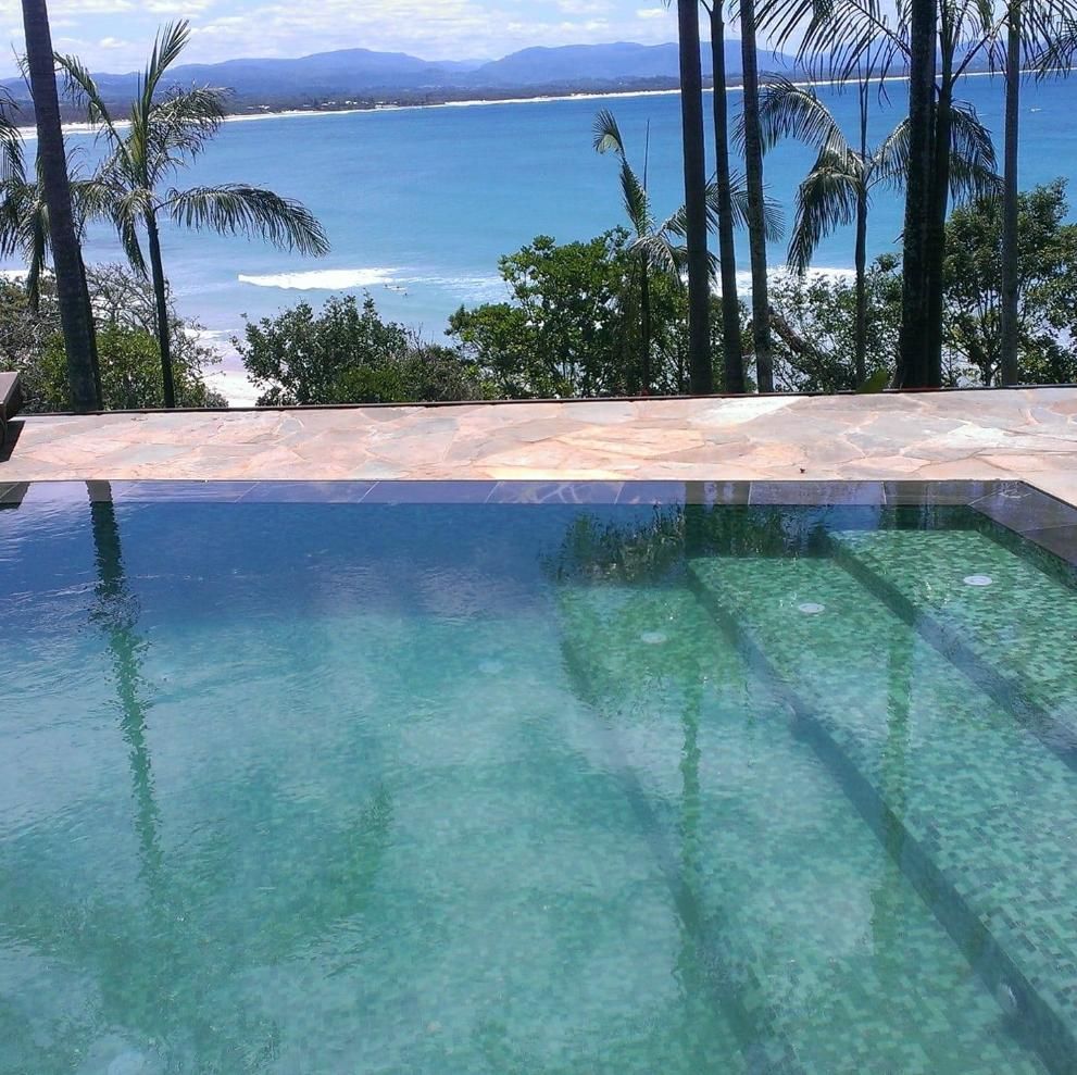 A Swimming Pool With A View Of The Ocean And Palm Trees — Ballina Pool Shop In Bangalow, NSW