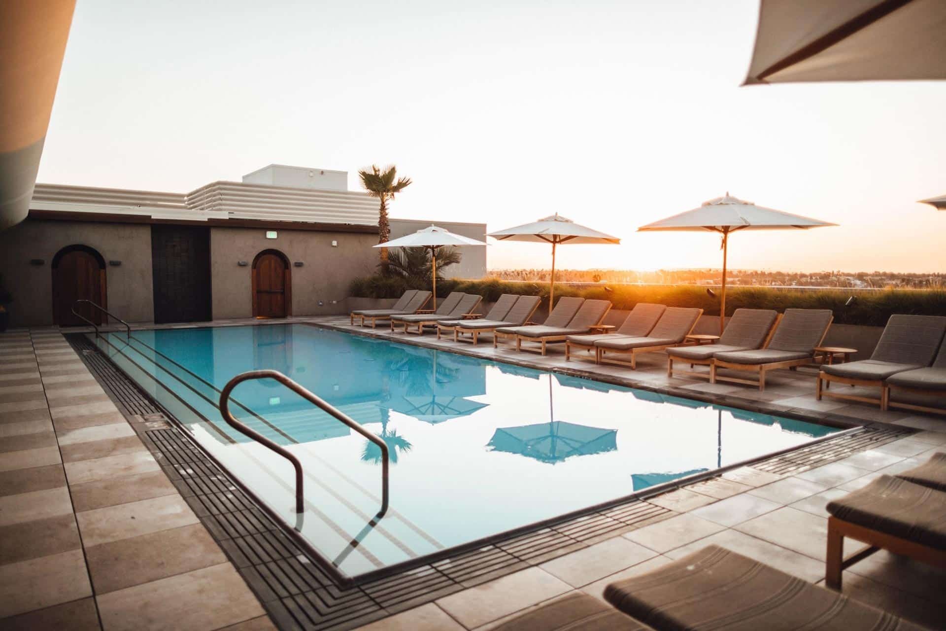 A Large Swimming Pool Surrounded By Chairs And Umbrellas — Ballina Pool Shop In Ballina, NSW