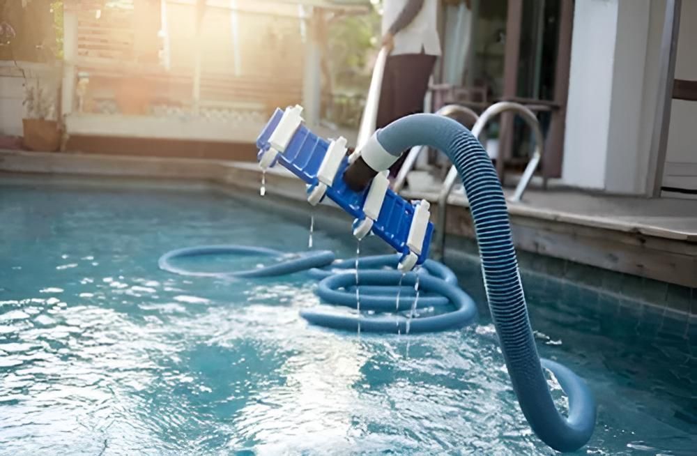 A Person Is Cleaning A Swimming Pool With A Vacuum Cleaner — Ballina Pool Shop In Byron Bay, NSW