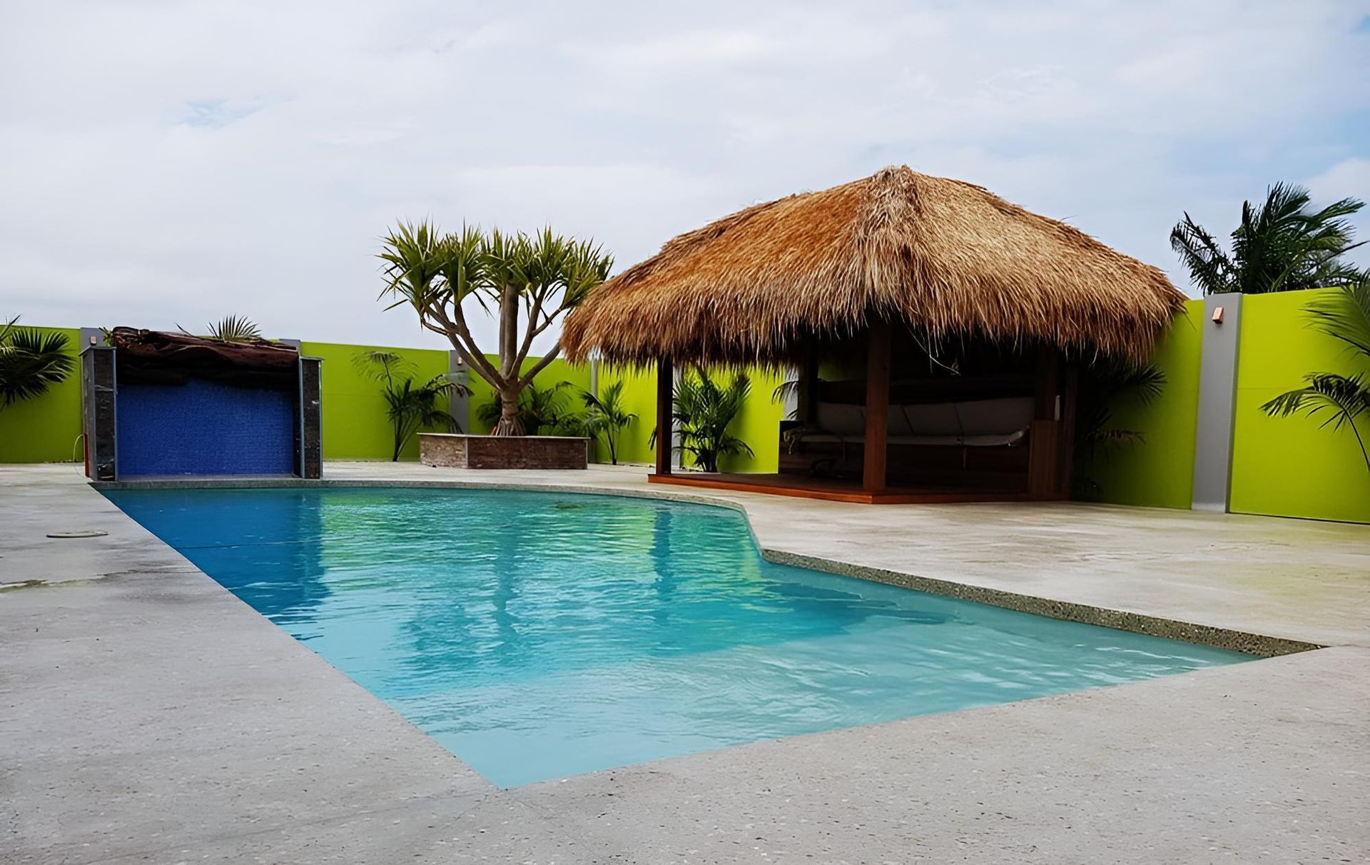 A Swimming Pool With A Thatched Hut In The Background — Ballina Pool Shop In Ballina, NSW