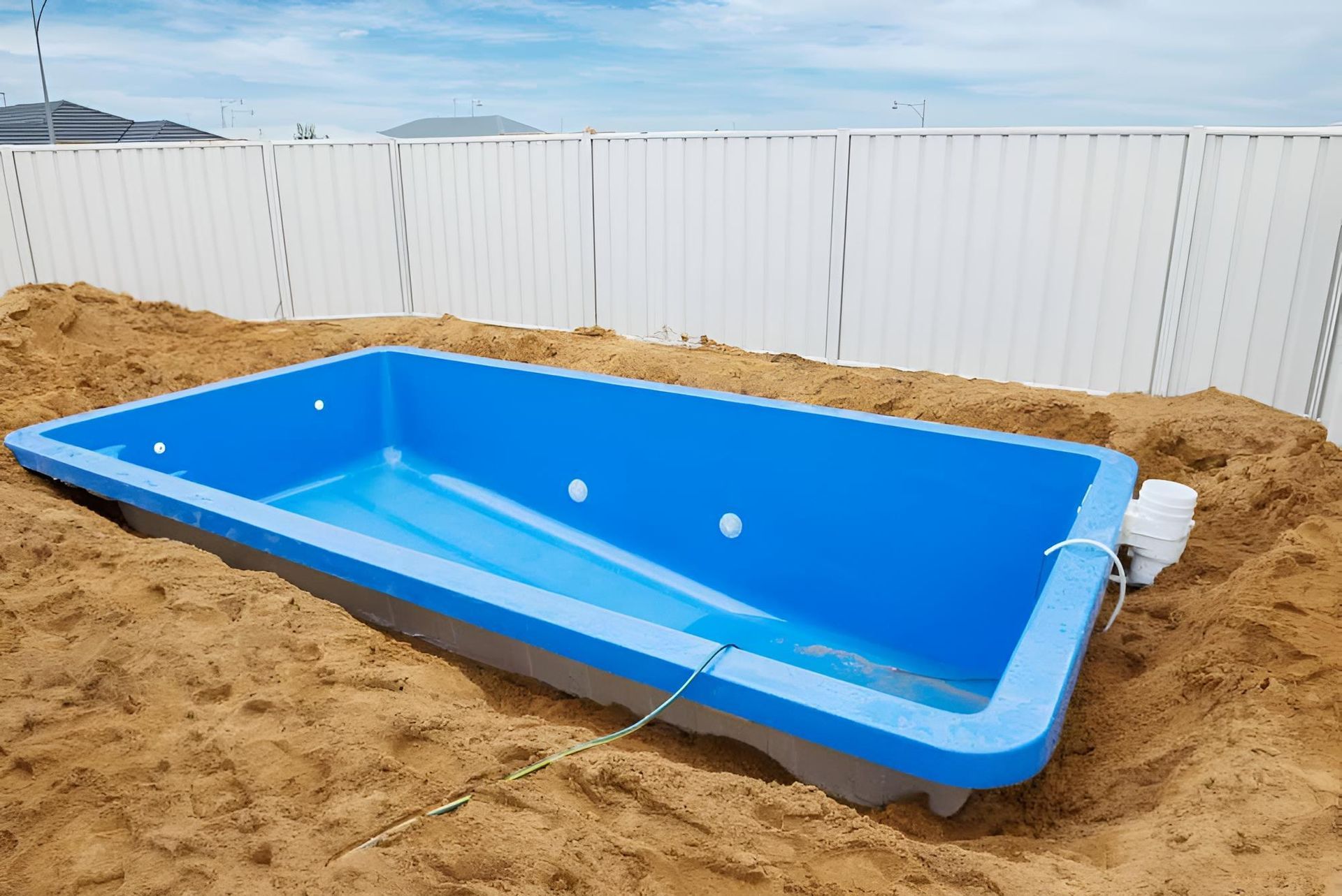 A Blue Swimming Pool Is Being Built In The Sand — Ballina Pool Shop In Ballina, NSW