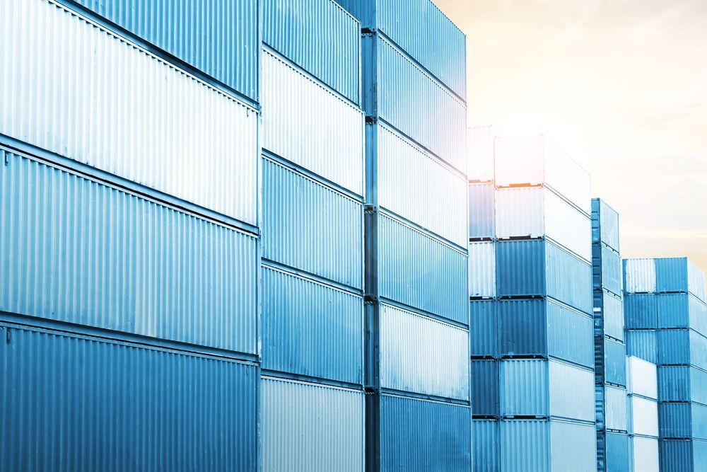 A row of blue and white shipping containers stacked on top of each other.