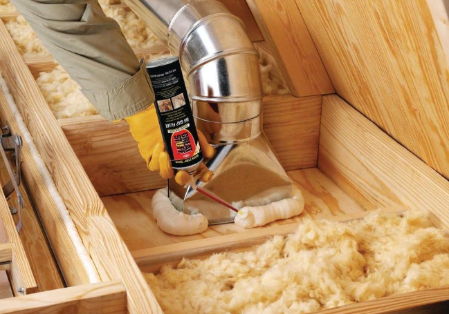 Close-up of a wooden loft with insulation, ductwork, and a mouse trap baited with food.