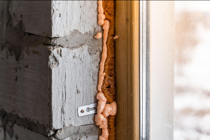 Foam insulation filling a gap between a wall and a window frame