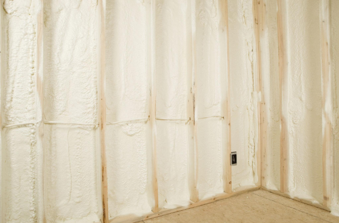 White insulated walls and beige carpet in an unfinished room corner