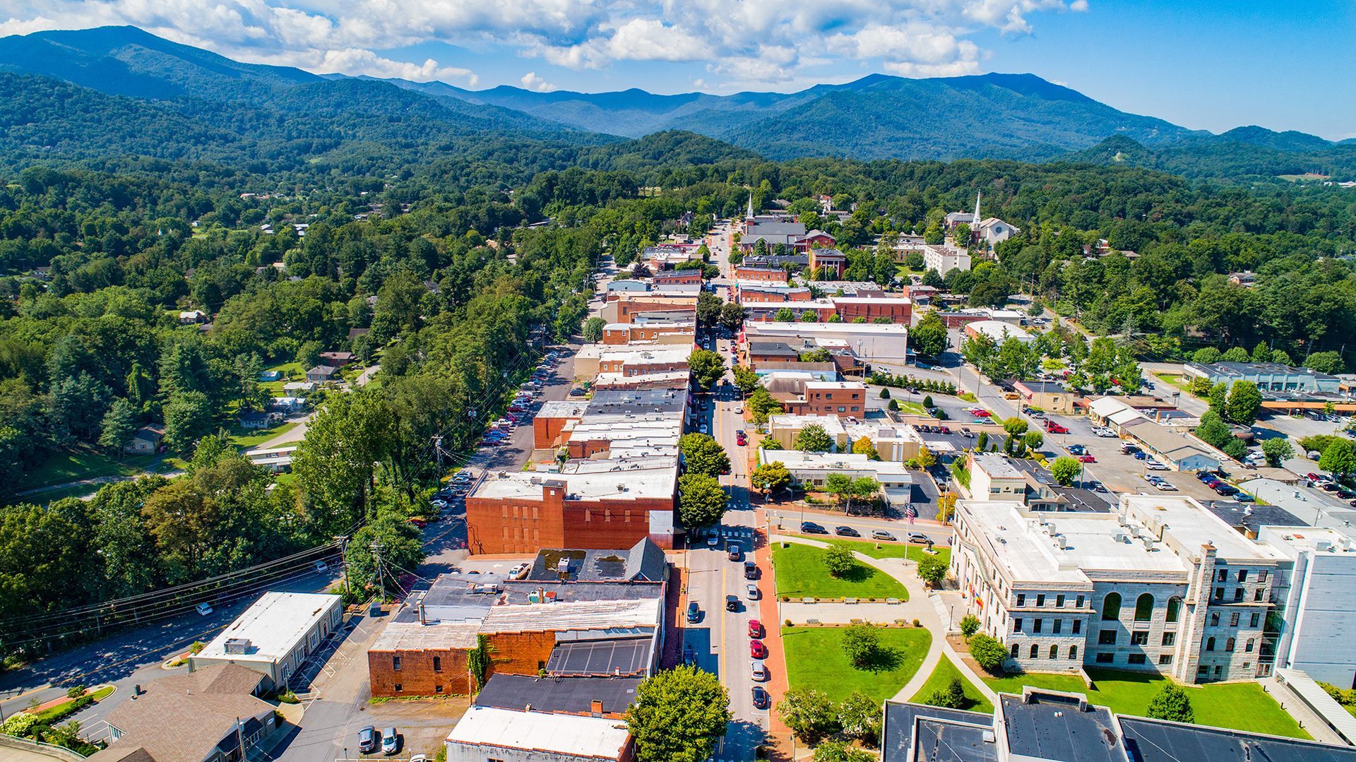 An aerial view of a small town with mountains in the background