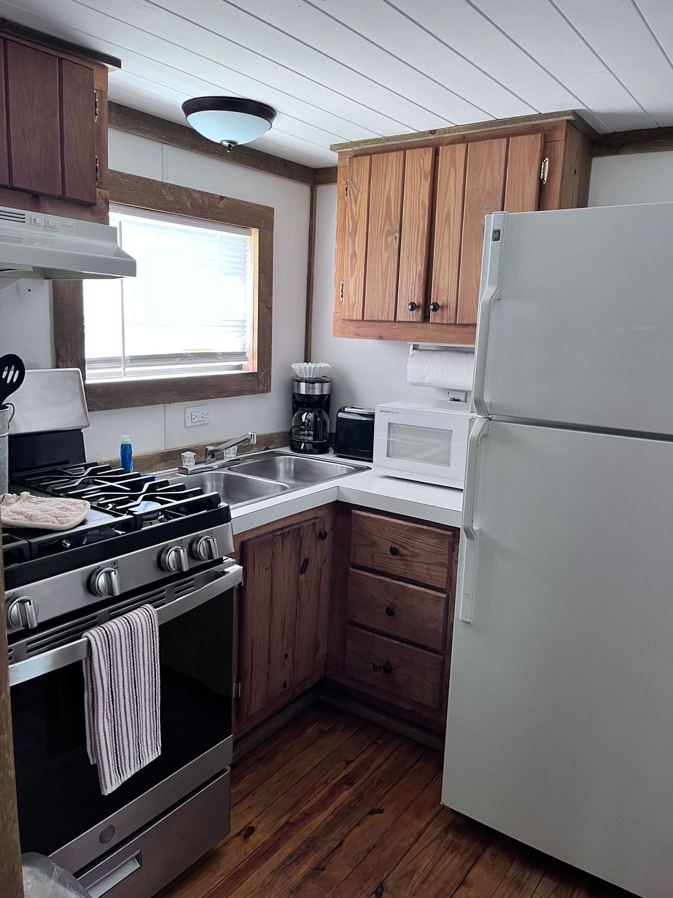 A kitchen with a stove top oven and a white refrigerator