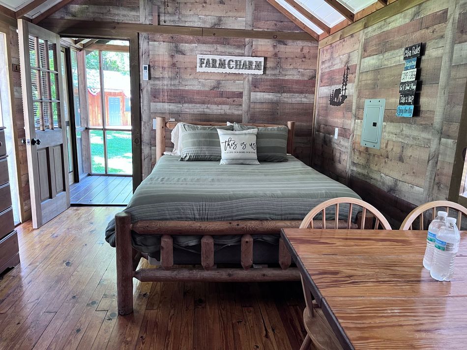 A bedroom in a log cabin with a bed and a table