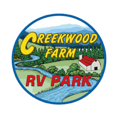 Logo for Creekwood Farm RV Park featuring a winding river, green hills, mountains, a barn, and text in a circular frame.
