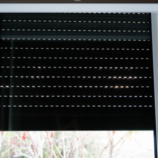 A close up of a black roller shutter on a window