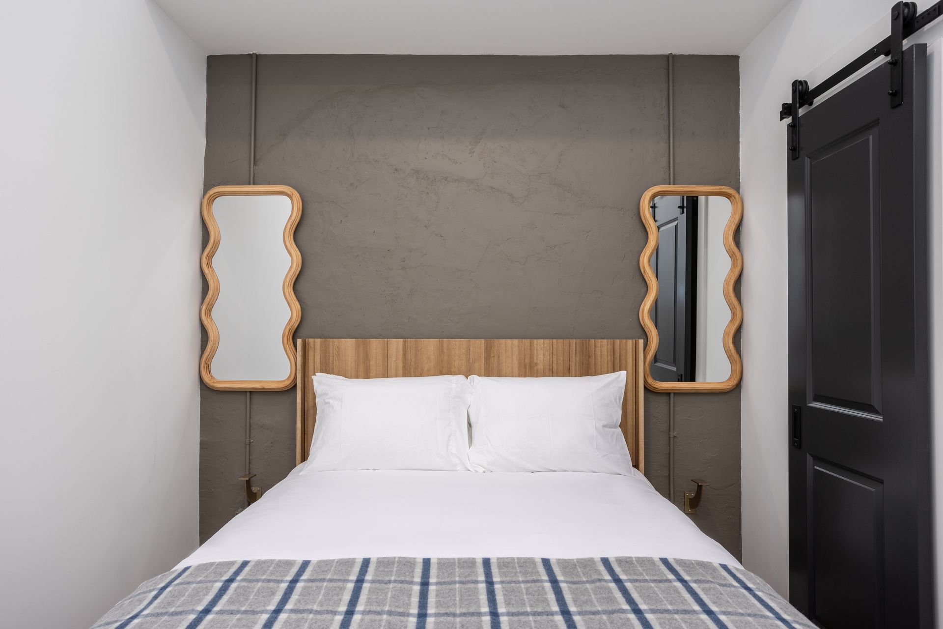 Bed and wavy mirrors on a wall.