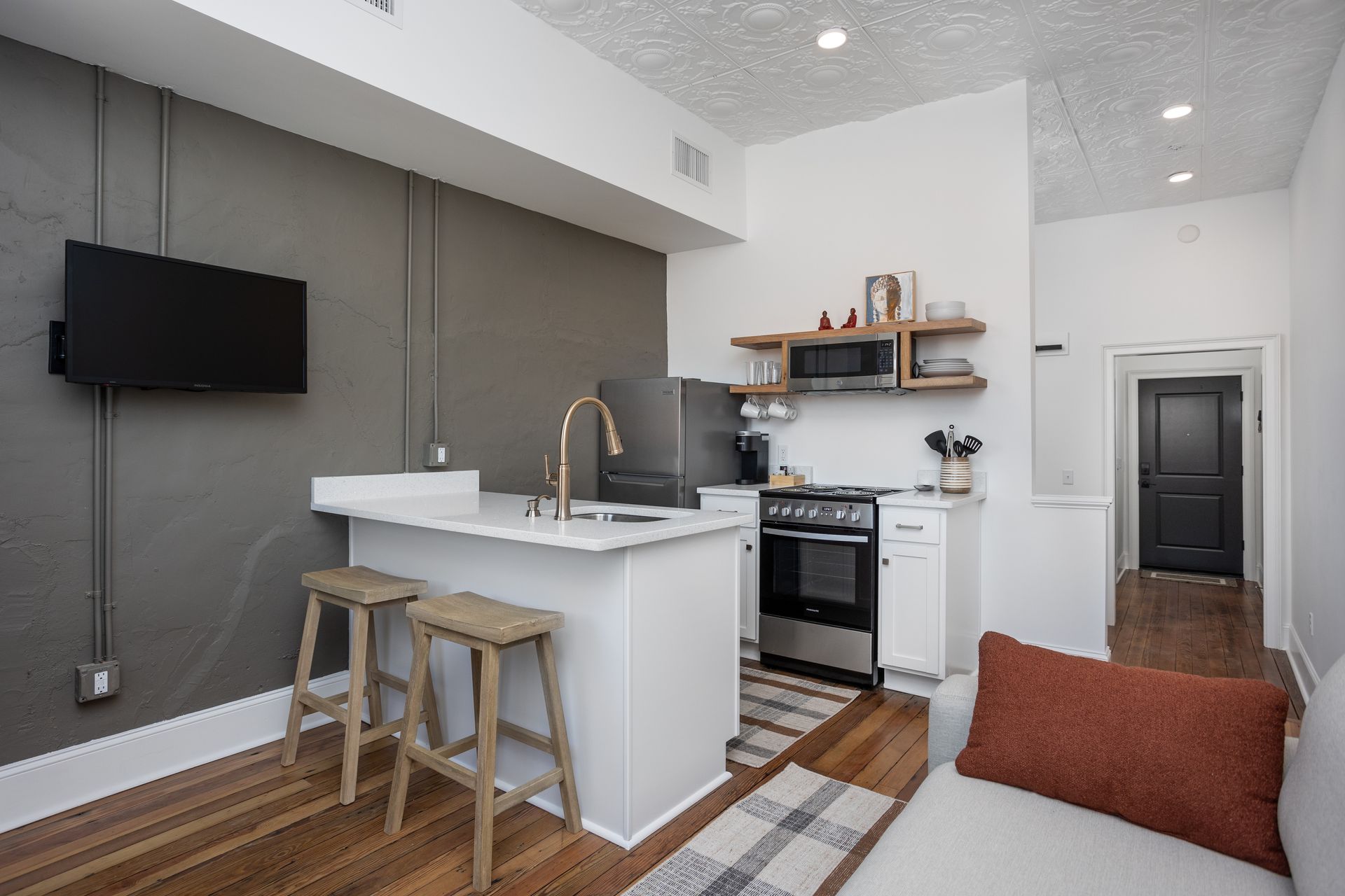 Galley kitchen with wooden counter stools.