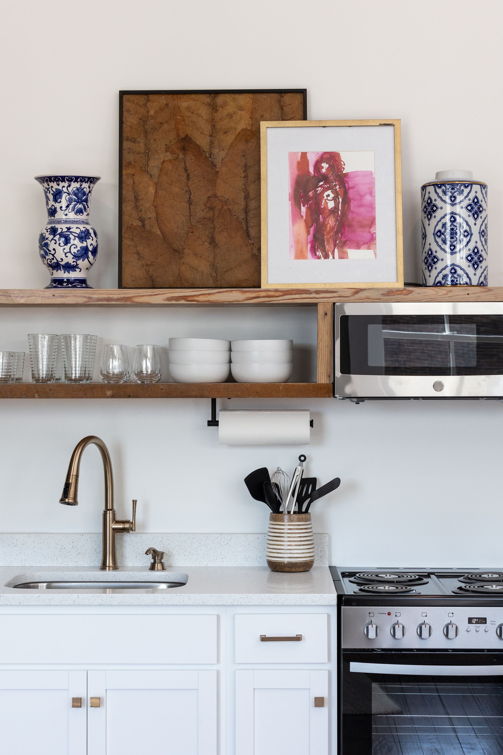 Kitchen with open shelving, art and a microwave