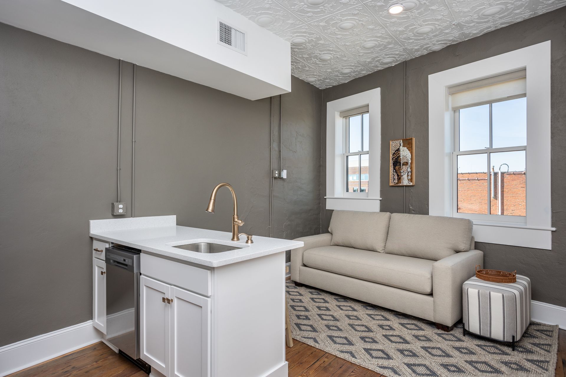 Studio apartment interior with a kitchen island and tan sofa.