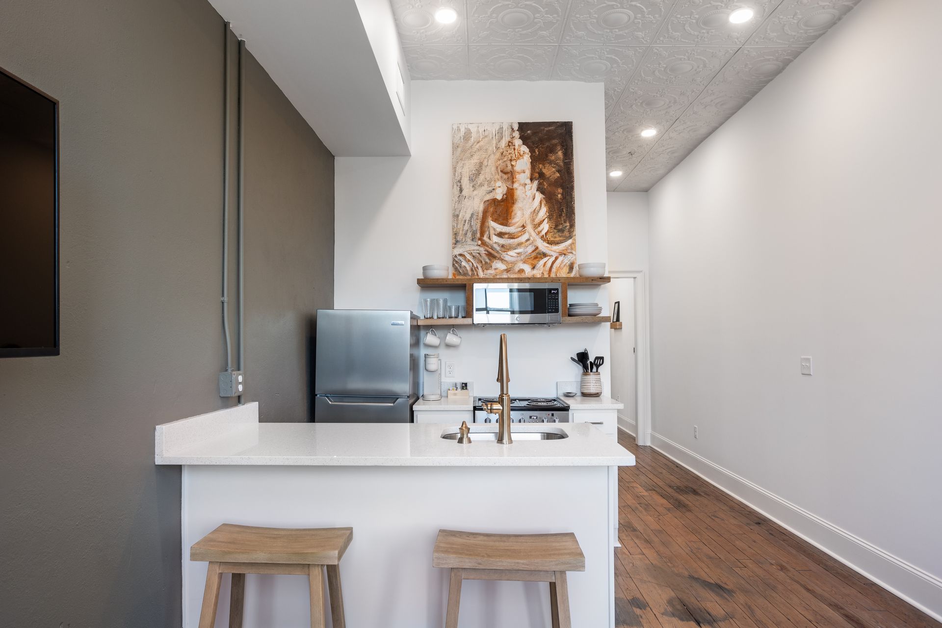 Galley kitchen. with open shelving and wooden bar stools.