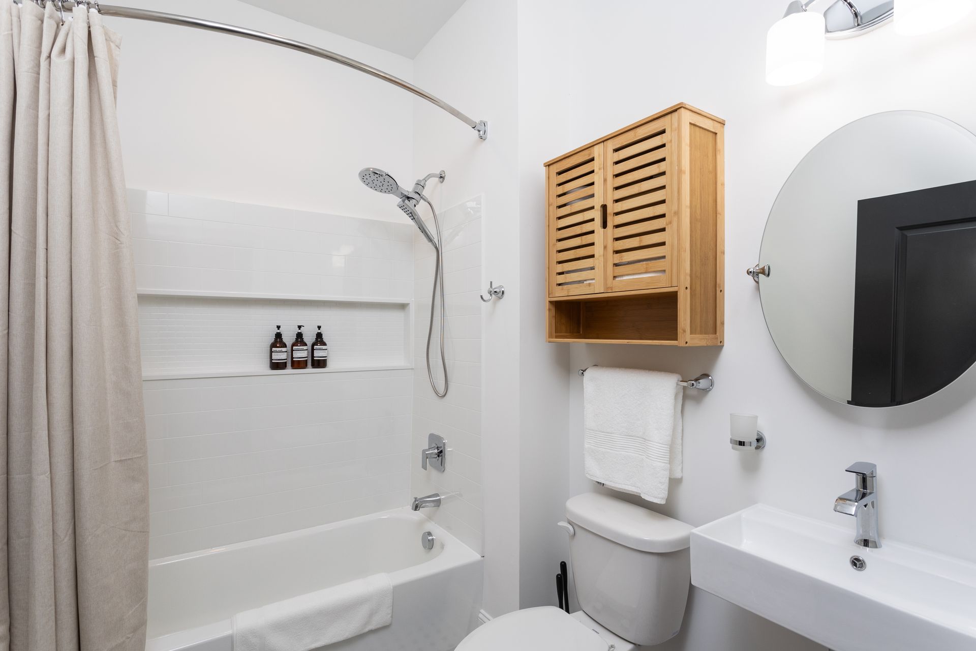 Bathroom with wooden cabinet. Tan shower curtain.