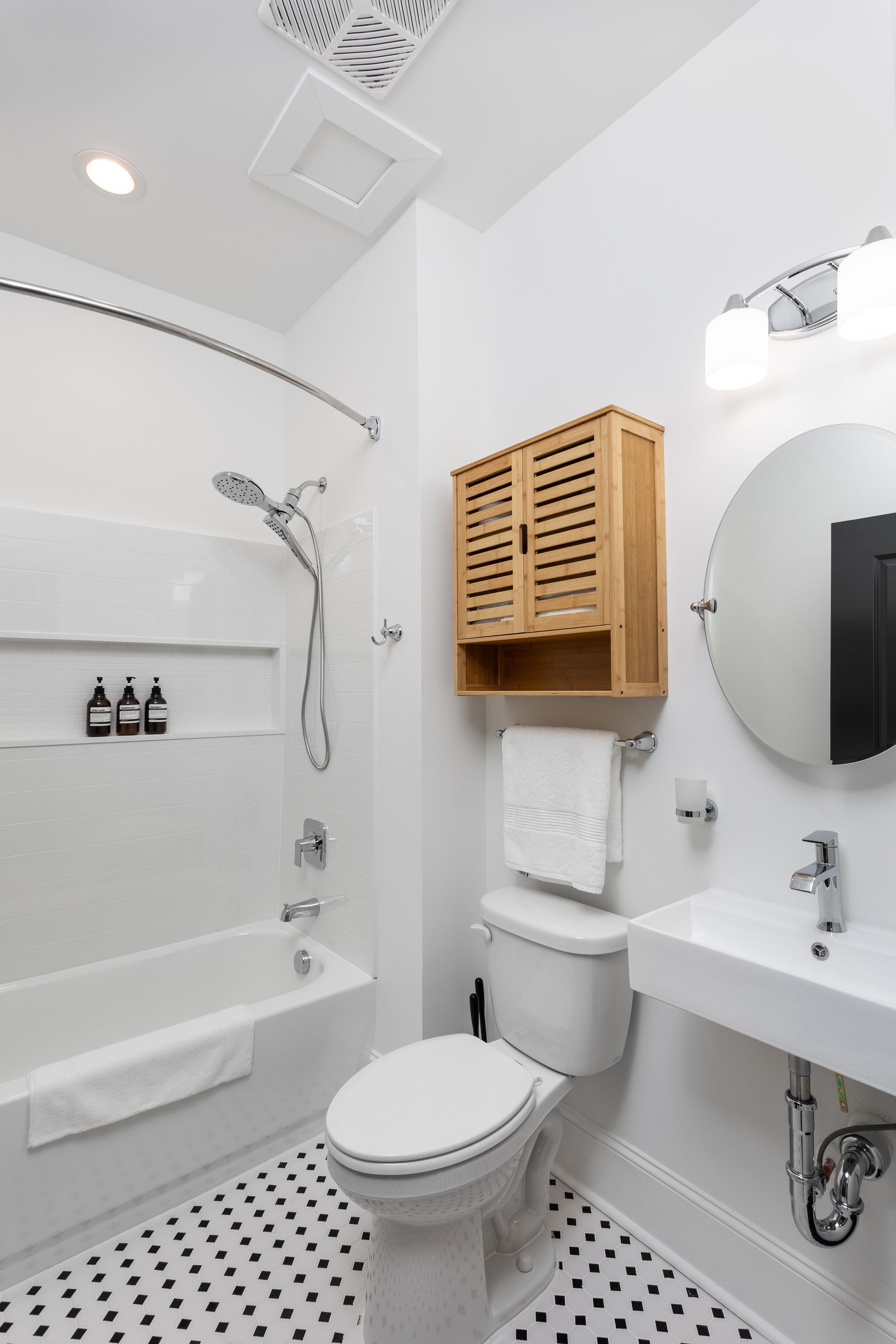 Bathroom with a hanging wood cabinet.