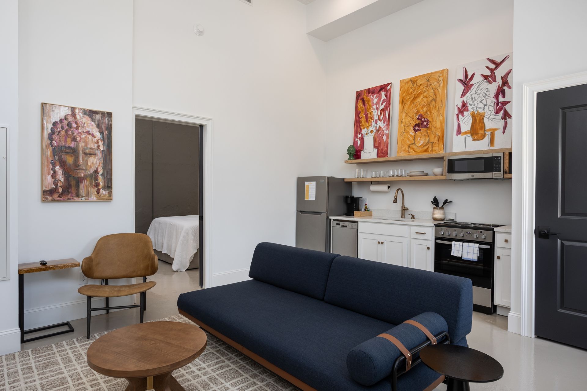 Living room with blue sofa. Kitchen in the background