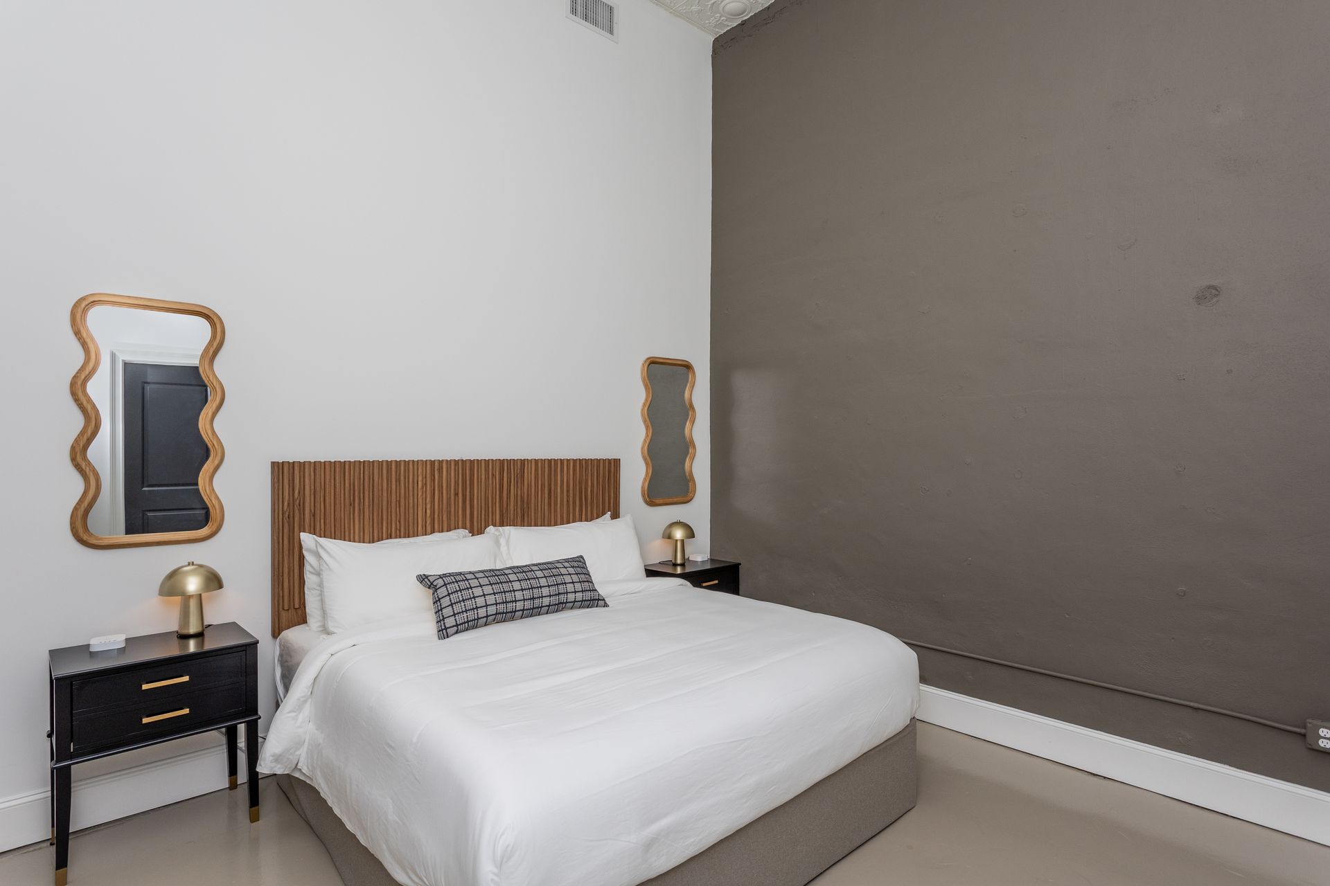 Bed with black nightstands and mirrors